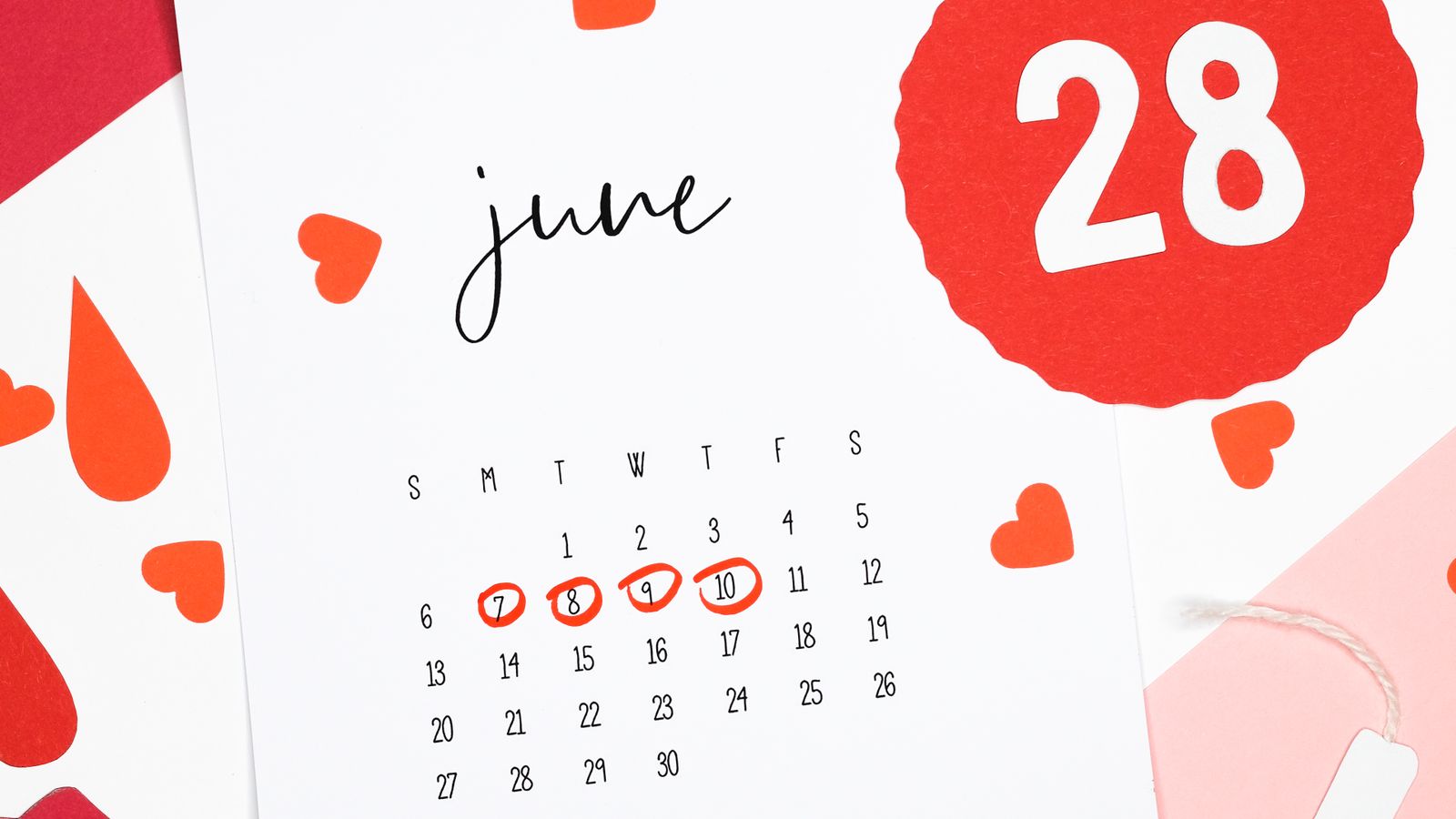Mujer consultando el calendario de su ciclo menstrual en una app, con expresión reflexiva junto a una taza de té